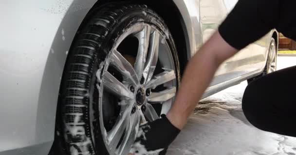Zbliżenie na mężczyznę myjącego samochód, zbliżenie na faceta myjącego ręce. Myjnia samochodowa. Rozsiewanie piany na błyszczącym samochodzie zewnętrznym zwolnionym tempie. Myjnia samochodowa lub samochód Szczegółowe ceny. 4k — Wideo stockowe