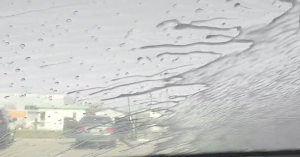 Close view of water and detergent on windscreen or windshield of car in drive through touchless car wash. The process of washing the car in a self-service car wash. 4k — Stock Video