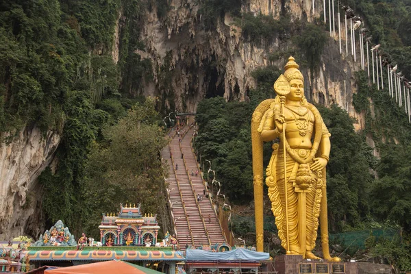 バトゥ洞窟の前にある巨大な金のヒンドゥ像 ストックフォト