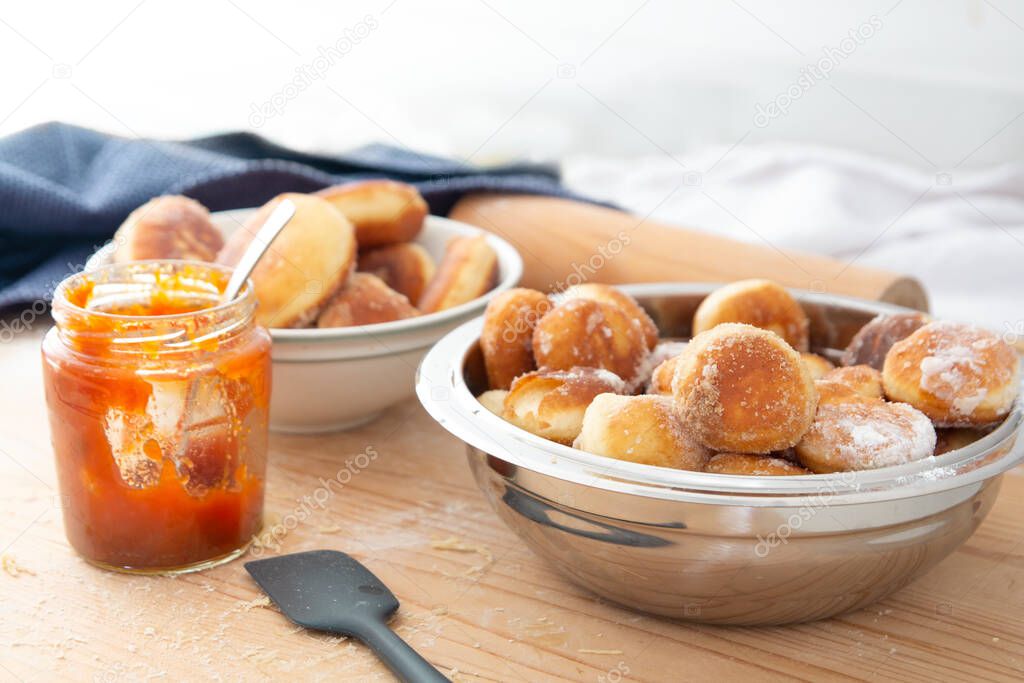 bowl full of homemade sugar donuts with jam