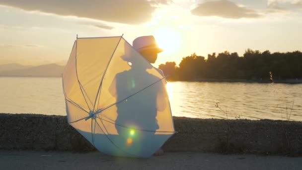 Un chico caminando por el muelle. Concepto de infancia feliz. Fondo de viajero feliz. Joven turista pasando tiempo en la playa. Concepto turístico. Puesta de sol en la orilla del mar con el niño en foco. Agencia de viajes adv — Vídeo de stock