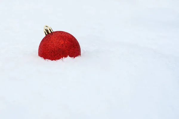 メリークリスマス白い雪の上のクリスマスの装飾。白い雪の上に赤いクリスマスボール。冬休みの背景。メリー・クリスマスの挨拶壁紙白地に輝く一つの物体 — ストック写真