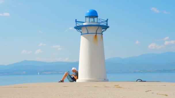 Διαδικτυακή ιδέα αγορών. Εξοικονόμηση κόστους. Πολύτιμη συμπεριφορά των πελατών. Λιανικό εμπόριο. Ανεξάρτητη δουλειά. Ταξίδεψε σε όλο τον κόσμο. Τεχνολογίες και Φύση. Αρσενικό με σημειωματάριο κοντά φάρο — Αρχείο Βίντεο