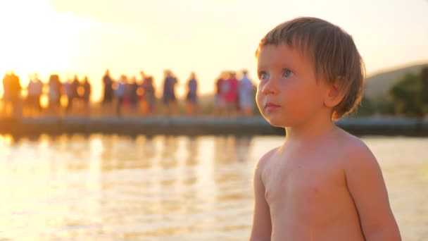 Bambino in piedi sulla riva del mare durante il tramonto. Salute mentale. Psicologia infantile. Espressione facciale. Uno sguardo speciale. Giovane turista vicino al mare. Vacanza con bambino. Sfondo infantile — Video Stock