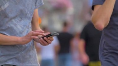 Sokakta cep telefonu olan bir erkek. Yetişkin bir erkek akıllı telefondan numara çeviriyor. Akıllı telefonun dokunmatik ekranına dokunmak. Tüm dünyaya bağlanan cep telefonlu bir yetişkin.