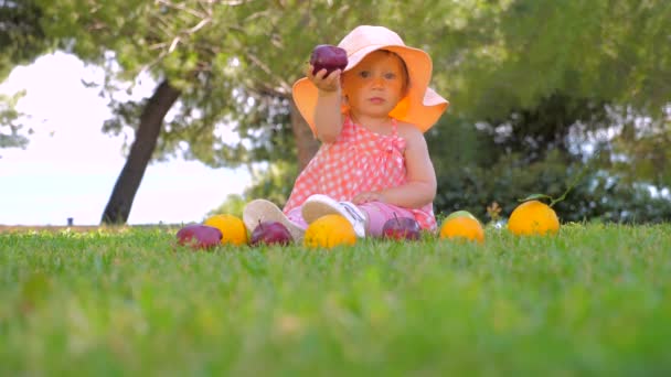Dagis bakgrund. Friska och glada barn leker utomhus. Vacker flicka leker med frukt på gården. Sommarskörd. Begreppet höstskörd. — Stockvideo