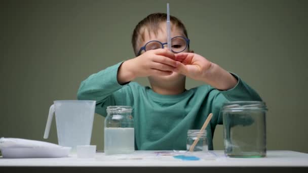 Επιστήμονας παιδικής ηλικίας Μαθαίνει στο εργαστήριο χημείας. Αγόρι, μαθαίνοντας και κάνοντας ένα χημικό πείραμα και κρατώντας δοκιμαστικό σωλήνα στα χέρια στο μάθημα της επιστήμης στο τραπέζι. Εκπαιδευτική έννοια — Αρχείο Βίντεο