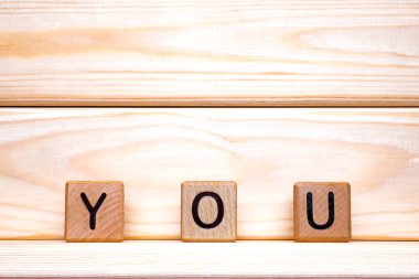 You word concept. The word You on wooden cubes. You constructed with wooden cubes on wooden background. You concept. You background