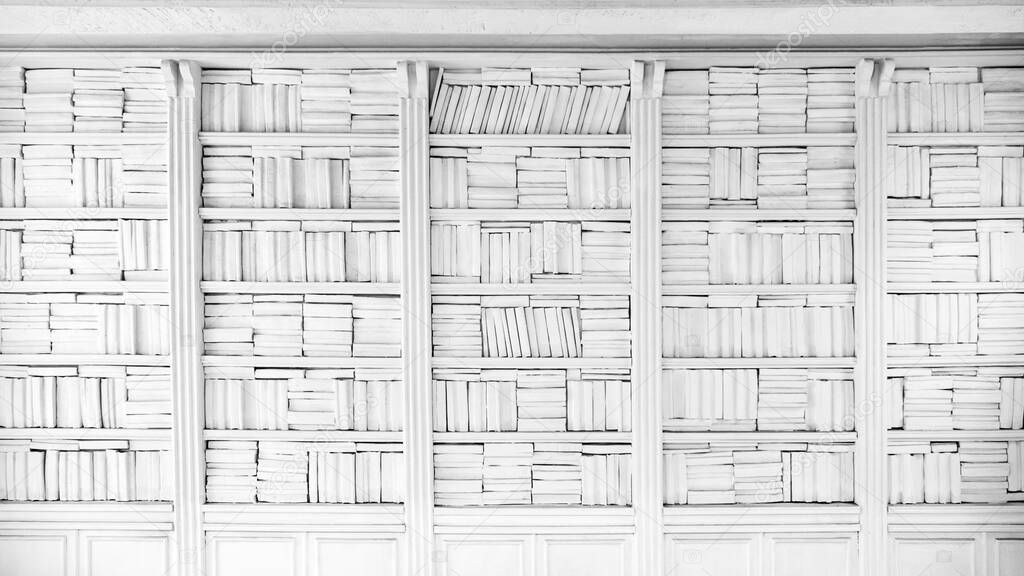 Background of large bookshelf on the wall. Many books in the side. White textured wall background. White wall background. Clean white wall with a bookcase with accurate monophonic books
