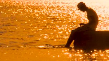 Dağlarda dizüstü bilgisayarla çalışan serbest çalışan bir adam. Blogcu dağın tepesinde çalışıyor. Gezgin blogcu, doğada dizüstü bilgisayarı olan bir hipster. İş konsepti. Canlı yayın, iletim arkaplanı