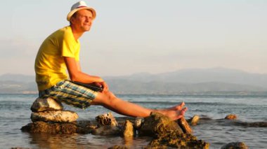 Hipster looking at the horizon on the sea. Travel blogger with notebook relaxing and enjoing sun at seaside. Traveling concept. Freelancer background. The end of the project. Future job concept.