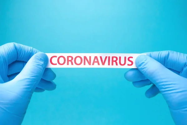 Covid-19 de fundo. Pare de se espalhar e eliminar o Coronavirus. Coronavírus das pandemias. Encosto epidêmico. Antecedentes de saúde. Mãos em luvas médicas azuis rasgando o papel com impressão covid-19 — Fotografia de Stock