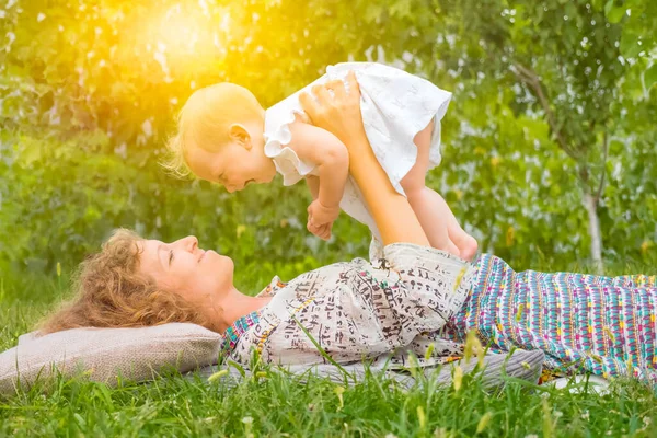 Праздники: С Днем Матери. Мать с ребенком на открытом воздухе. Положительные эмоции матери и малыша. Счастливая семья. Счастье в материнстве. Любовь и забота — стоковое фото