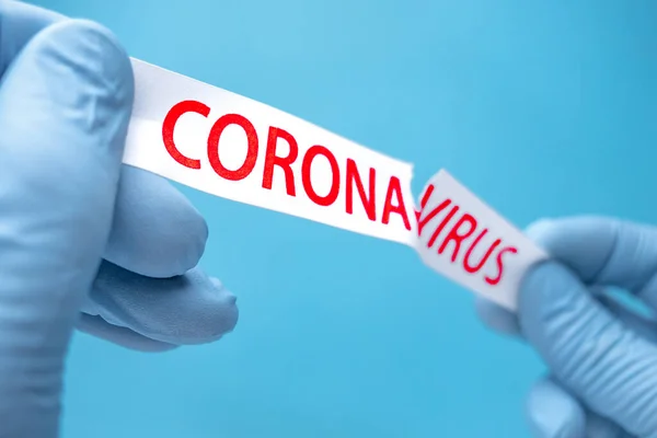 Covid-19 de fundo. Pare de se espalhar e eliminar o Coronavirus. Coronavírus das pandemias. Encosto epidêmico. Antecedentes de saúde. Mãos em luvas médicas azuis rasgando o papel com impressão covid-19 — Fotografia de Stock
