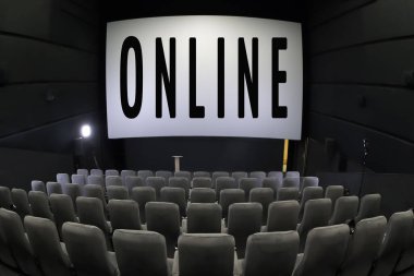 İnternetteki işinizi genişletiyorsunuz. Karantina konsepti. Çevrimiçi arka planı izle. Boş koltuklu sinema. Sahnede bir söz var. Koronavirüs salgınından kaynaklanan olay yayını