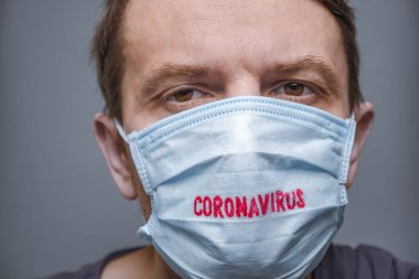 Coronavirus COVID-19. Salgın geçmişi. Tıbbi maske ve eldiven takmış yorgun bir adamın yüzü. Yoksul erkek ve yeni onaylanmış Coronavirus hastalığı COVID-19 vakaları. Olumsuz duygular. Yüz ifadesi.
