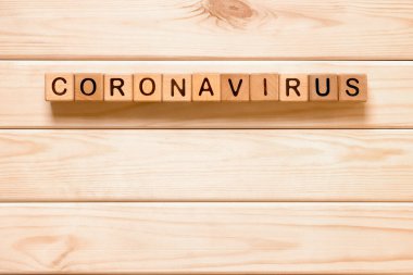 Tahta bloklu kelime Coronavirus, tahta arka planda küpler. COVID-19. Kendini soyutlama konsepti. Coronavirus karantinası. Evden çalışıyorum. Ev konseptinde kal.