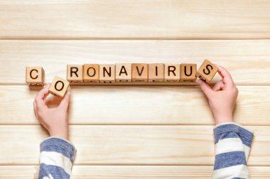 Çocuklar ve koronavirüs. Çocuk psikolojisi. Çocuk elleri Coronavirus kelimelerini yayıyor. Salgın, salgın ve çocuk. Karantina, evde çocuklar. Ev okulu