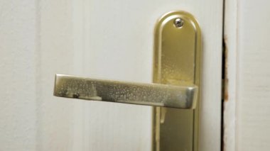 Kapı tokmağını dezenfekte eden eldiven. COVID-19, koronavirüs. Salgın geçmişi. Karantina, evi ve hastaneyi dezenfekte etmek. Virüs ve bakterilerden dezenfekte etmek
