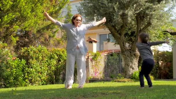 Restez en forme pendant la quarantaine. Famille faisant des exercices du matin en plein air. Grand-mère et petit-fils faisant des exercices matinaux sur l'air frais près de la maison. Sport pendant la quarantaine COVID-19 — Video