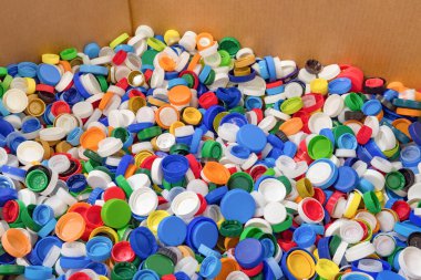 Plastik şişe mantarı yığını. Geri dönüşüm için plastik atık. Plastik malzemeyi geri dönüştürüyorum. Plastik çöp. Fabrikada geri dönüşümü bekleyen büyük bir atık yığını var. İşlem istasyonu.
