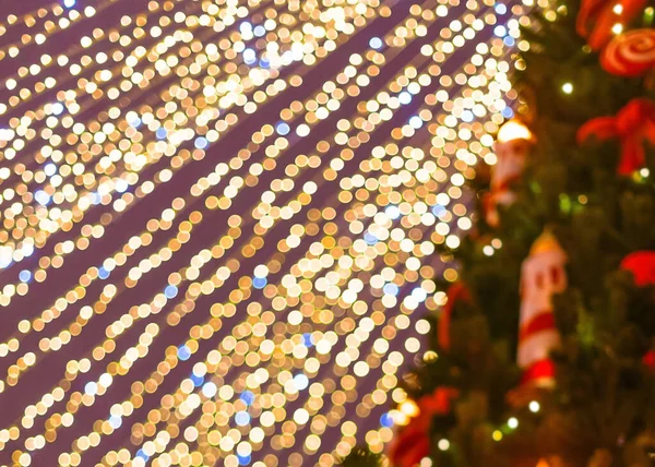 Christmas string lights defocused with christmas tree on the right. Postcard. Bokeh background. — Stock Photo, Image