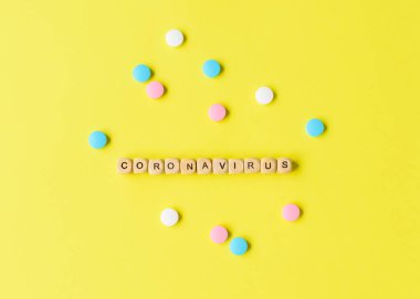 Coronavirus konsepti. Sarı arkaplanlı haplar ve boncuklar. Bulaşıcı virüs konsepti.