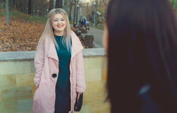 Um retrato de uma menina bonita, de pé atrás de uma mulher em um parque de outono. — Fotografia de Stock