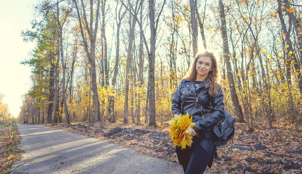 Schöne Frau posiert im herbstlichen Wald. Mädchen in schwarzer Lederjacke spaziert im Wald — Stockfoto