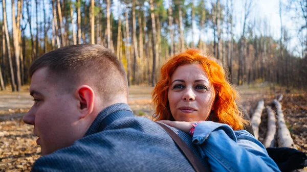 Portrait d'un couple marié dans la forêt d'automne. La femme s'est penchée avec attention sur l'épaule des hommes. — Photo