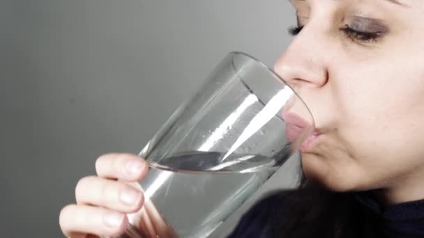 Agua potable femenina de un vaso de vidrio, cerca. — Vídeos de Stock