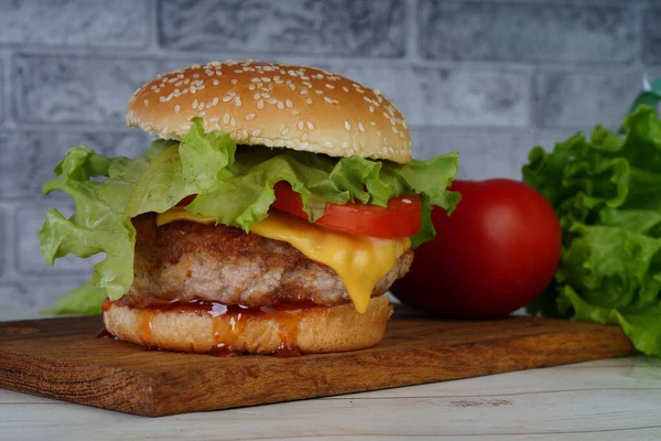 Hambúrguer caseiro com legumes frescos. Hambúrguer grelhado saboroso com carne, queijo, legumes. Delicioso Cheeseburger grelhado. Espaço livre para texto — Fotografia de Stock