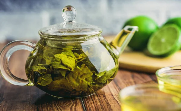 As folhas de chá são preparadas em água fervente e infundidas em um pequeno bule de chá. O conceito da festa do chá. Chá verde em um bule de chá — Fotografia de Stock