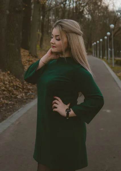 한 아름다운 소녀가 가을 공원의 골목을 따라 걷고 있습니다. — 스톡 사진