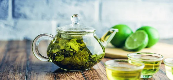 Les feuilles de thé sont infusées dans de l'eau bouillante et infuser dans une petite théière. Le concept du tea party. Thé vert dans une théière — Photo