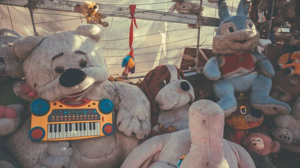 Velhos e maltratados brinquedos macios jazem na rua. O despejo dos brinquedos abandonados — Fotografia de Stock