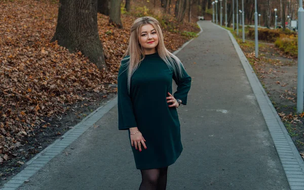 한 아름다운 소녀가 가을 공원의 골목을 따라 걷고 있습니다. — 스톡 사진
