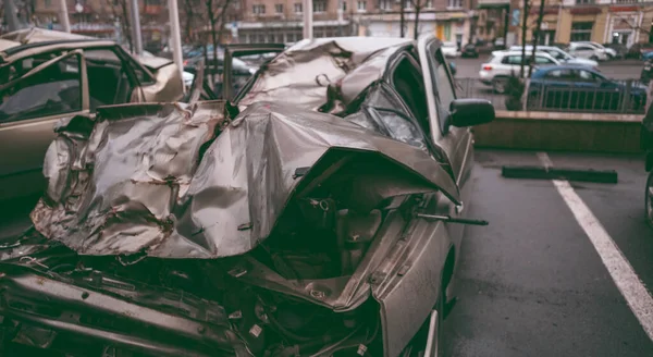 Bilen efter olyckan. En trasig bil på vägen. Kroppen på bilen är skadad till följd av en olycka. Höghastighetshuvud på en bilolycka. Dent på karossen efter en kollision på — Stockfoto