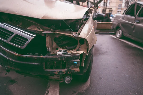 Bilen efter olyckan. En trasig bil på vägen. Kroppen på bilen är skadad till följd av en olycka. Höghastighetshuvud på en bilolycka. Dent på karossen efter en kollision på — Stockfoto