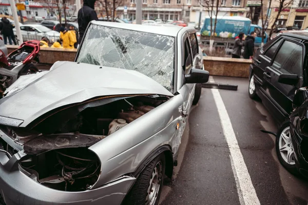 Bilen efter olyckan. En trasig bil på vägen. Kroppen på bilen är skadad till följd av en olycka. Höghastighetshuvud på en bilolycka. Dent på karossen efter en kollision på — Stockfoto