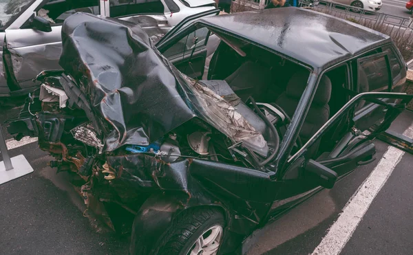 Το αμάξι μετά το ατύχημα. Σπασμένο αμάξι στο δρόμο. Το σώμα του αυτοκινήτου είναι κατεστραμμένο ως αποτέλεσμα ατυχήματος. Κεφάλι υψηλής ταχύτητας σε τροχαίο ατύχημα. Πτερύγια στο σώμα του αυτοκινήτου μετά από σύγκρουση με το — Φωτογραφία Αρχείου