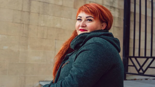 Kızıl saçlı, gülümseyen güzel bir kadının portresi..