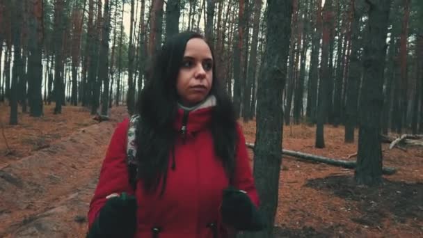 Ładna młoda kobieta jest zaangażowana w nordic walking w lesie. — Wideo stockowe