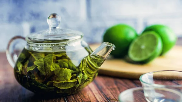 As folhas de chá são preparadas em água fervente e infundidas em um pequeno bule de chá. O conceito da festa do chá. Chá verde em um bule de chá — Fotografia de Stock