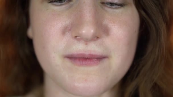 Um retrato da parte do corpo feminino em um fundo laranja. Uma jovem está comendo as batatas fritas douradas. Feche a boca. — Vídeo de Stock