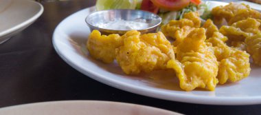 Beyaz soslu karides ve beyaz tabakta sebze.