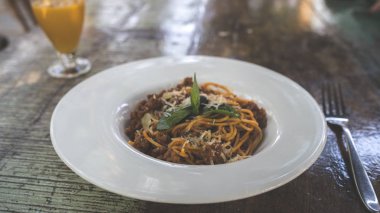Kırmızı soslu makarna, deniz ürünleri, beyaz tabak ve çatal bıçak.