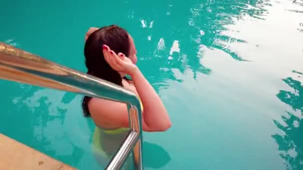Belle femme en maillot de bain jaune dans la piscine, en plein air — Video