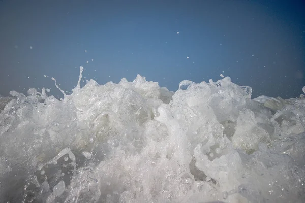 A maré baixa da praia de areia. Ondas oceânicas estão salpicando na costa . — Fotografia de Stock