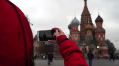 Genç bir kadın cep telefonuyla tarihi yerleri fotoğraflıyor. Kız Moskova Kremlin 'inin fotoğrafını çekiyor..